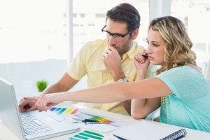 Two people deciding right blinds with help of Laptop and color shade card