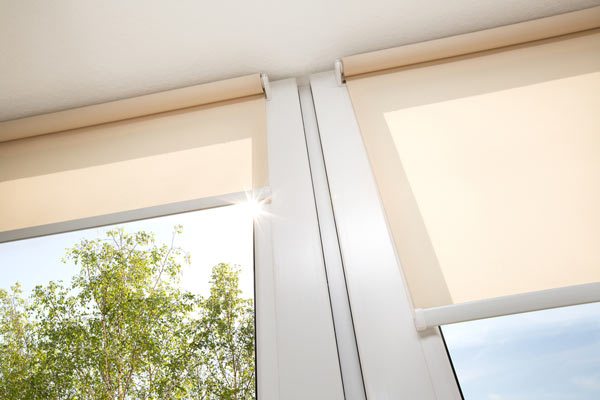 A window with sand coloured roller blinds