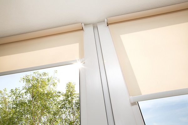 White roller sunscreen blinds in a glass room that protect sun light