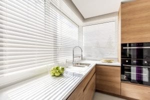 Modern bright kitchen interior with white horizontal window blinds