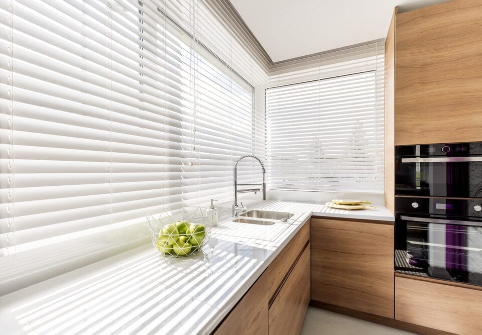 White horizontal blinds in modern kitchen.