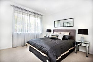 Modern bedroom with black decorations and grey luxury curtains. 