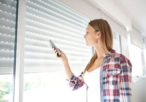 Woman using smartphone to control electric shutters 